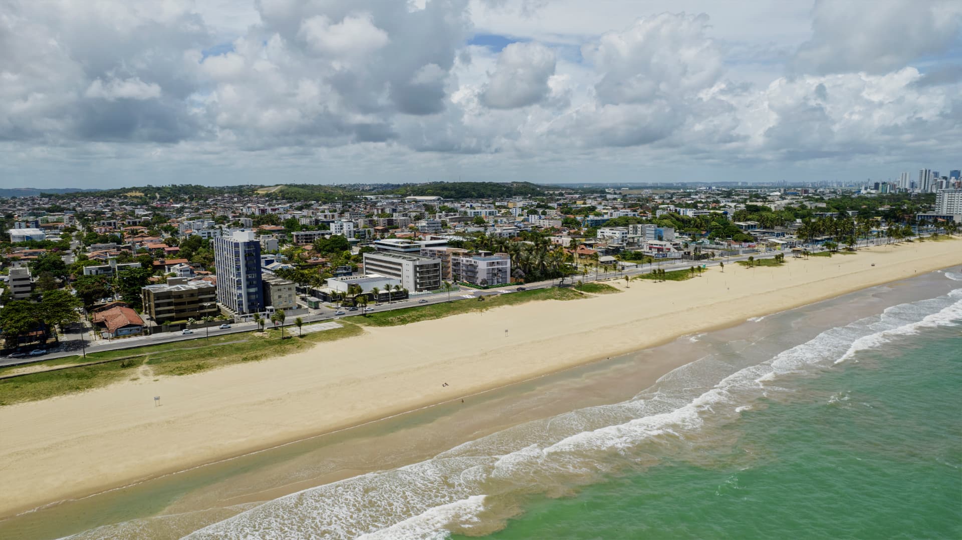 Vista aérea da orla mostrando a faixa de areia, o mar e a ocupação urbana onde se implanta o Oscar Freire