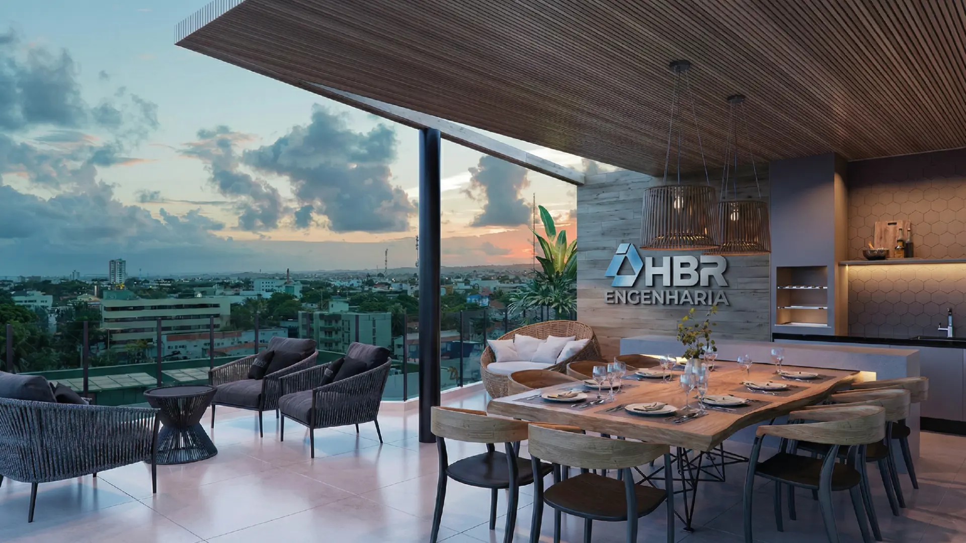 Espaço gourmet do rooftop com mesa de jantar, poltronas e vista da cidade ao entardecer